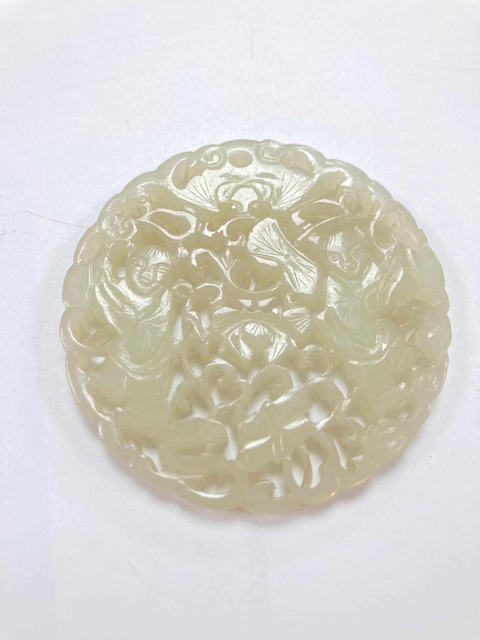 A Chinese white jade ‘Hehe Erxian’ disc, 19th/20th century, 5.6cm diameter, wood stand